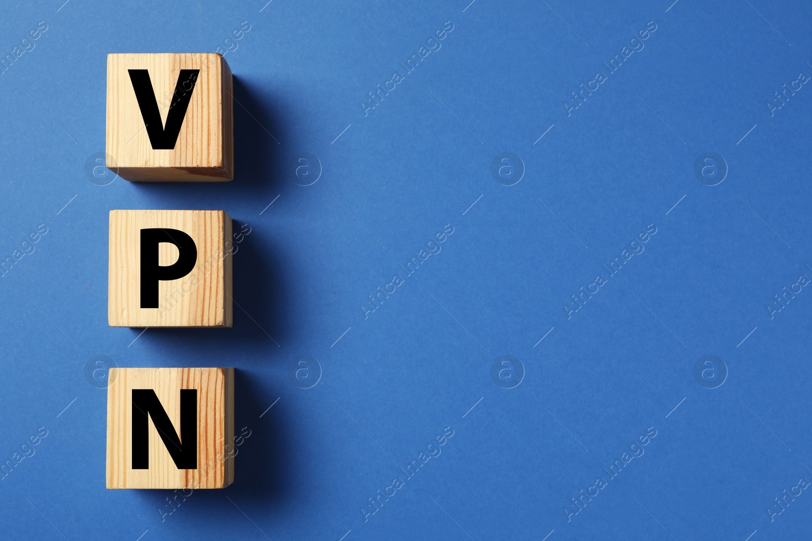 Image of Wooden cubes with acronym VPN on blue background, flat lay. Space for text