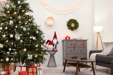 Beautiful Christmas tree, gift boxes and decor in living room. Interior design