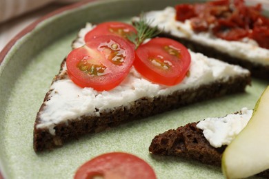 Delicious bruschettas with fresh ricotta (cream cheese), tomato and dill on plate, closeup