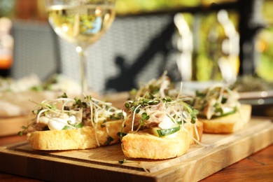 Delicious bruschettas with fish on wooden table