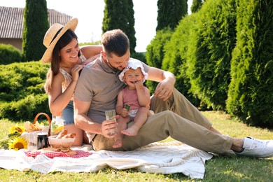 Happy family having picnic in garden on sunny day