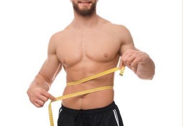 Photo of Athletic man measuring waist with tape on white background, closeup. Weight loss concept