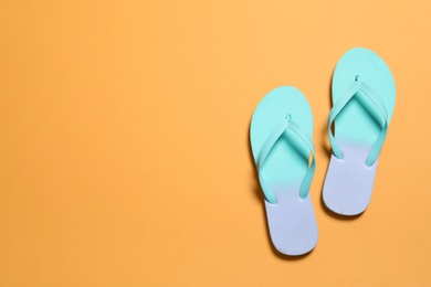 Bright flip flops on color background, top view with space for text. Beach accessories