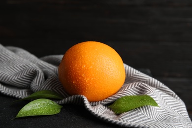 Fresh orange with leaves and napkin on table