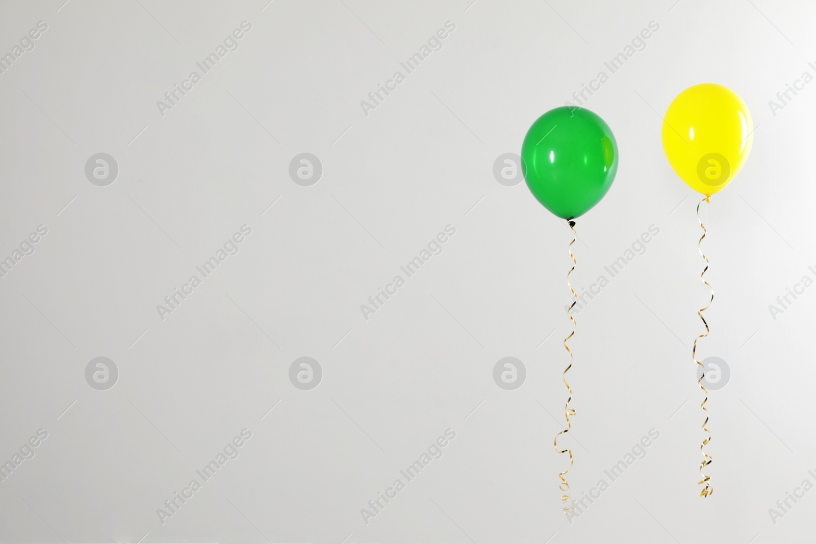 Photo of Different bright balloons on light background, space for text. Celebration time