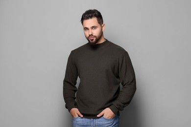 Photo of Handsome man in stylish sweater on grey background