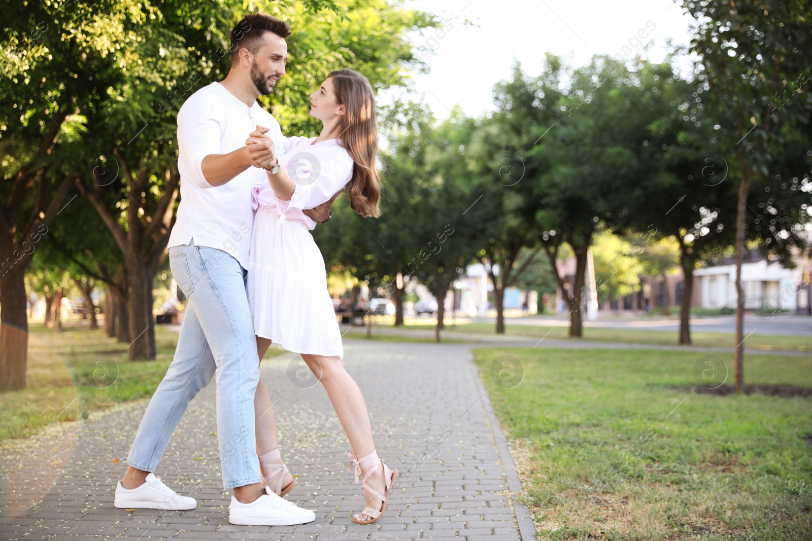 Photo of Lovely young couple dancing together in park on sunny day