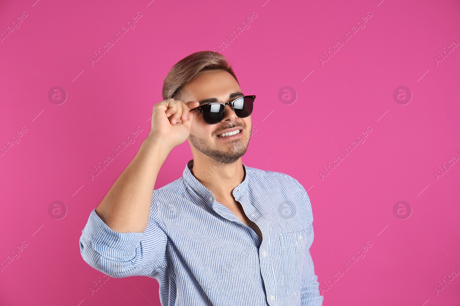 Photo of Young man with trendy hairstyle on color background