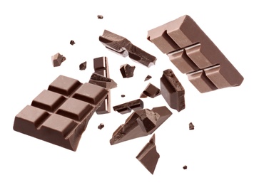 Milk chocolate pieces falling on white background