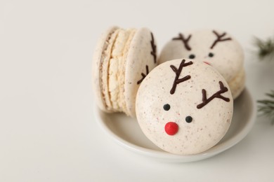 Photo of Tasty reindeer Christmas macarons on white background, closeup. Space for text