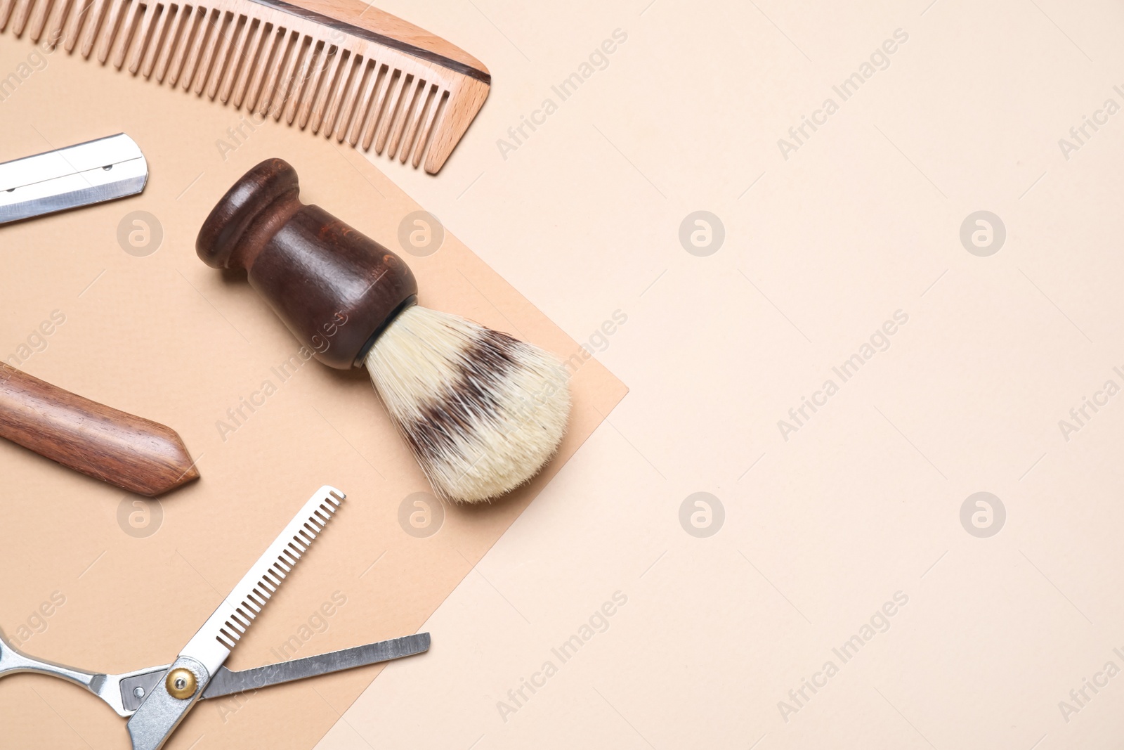 Photo of Set of barber's equipment on beige background, flat lay. Space for text