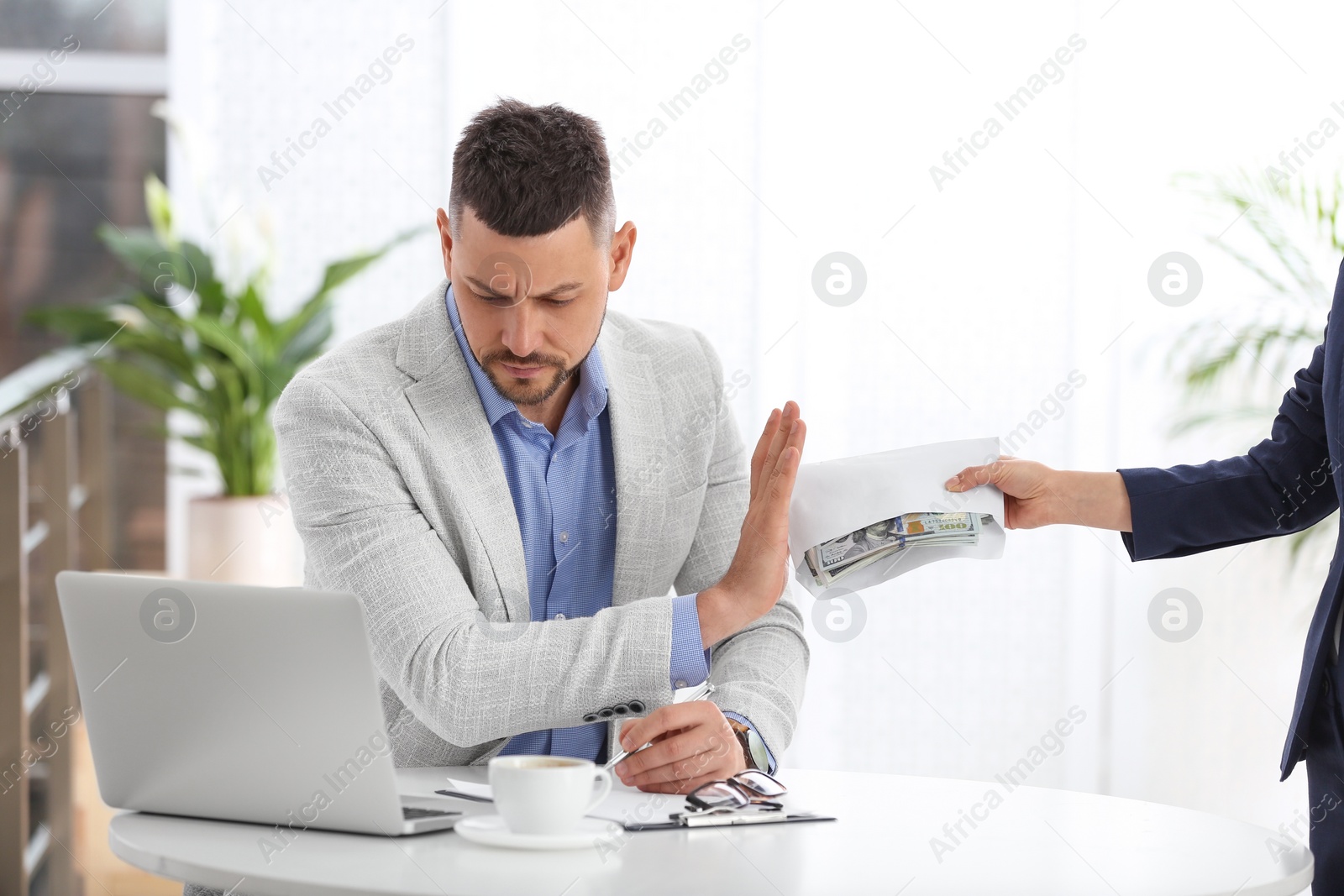 Photo of Businessman refusing to take bribe at table indoors
