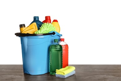 Photo of Light blue bucket and many different car wash products on black wooden table against white background