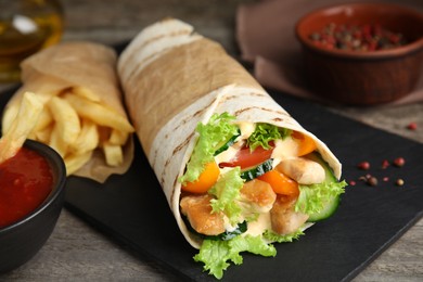 Photo of Delicious chicken shawarma on wooden table, closeup