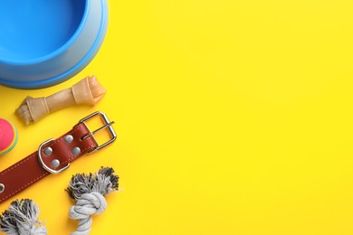 Flat lay composition with dog collar and different accessories on yellow background, space for text