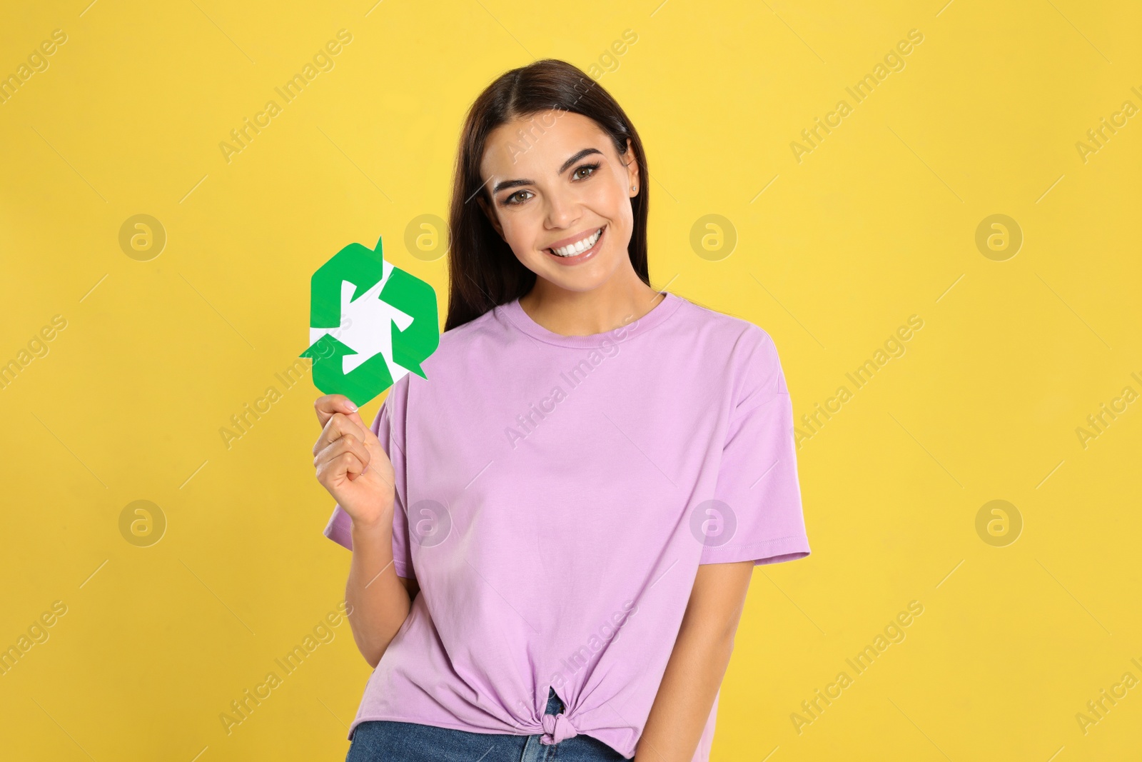 Photo of Young woman with recycling symbol on yellow background