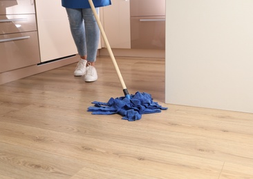 Photo of Woman washing floor with mop in kitchen. Cleaning service