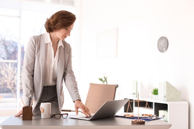 Female lawyer standing near table in office