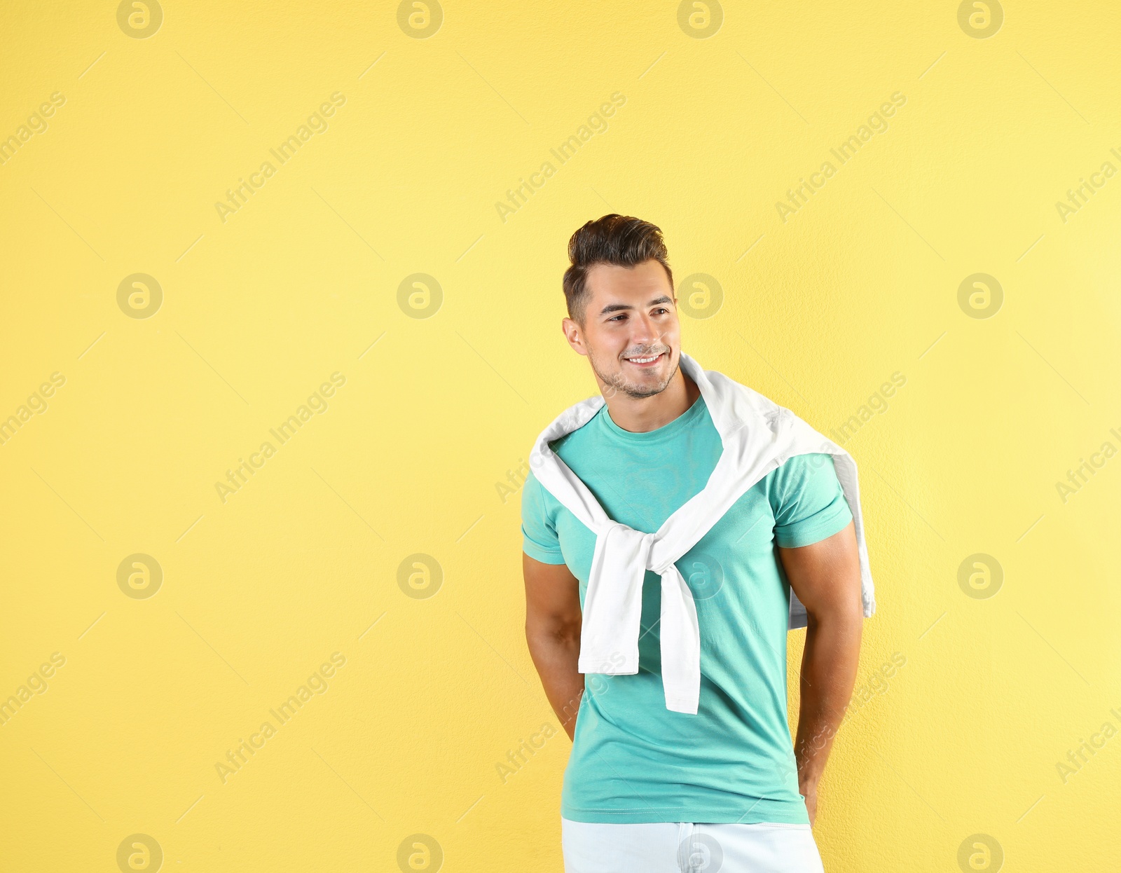 Photo of Young man in stylish jeans on color background with space for text