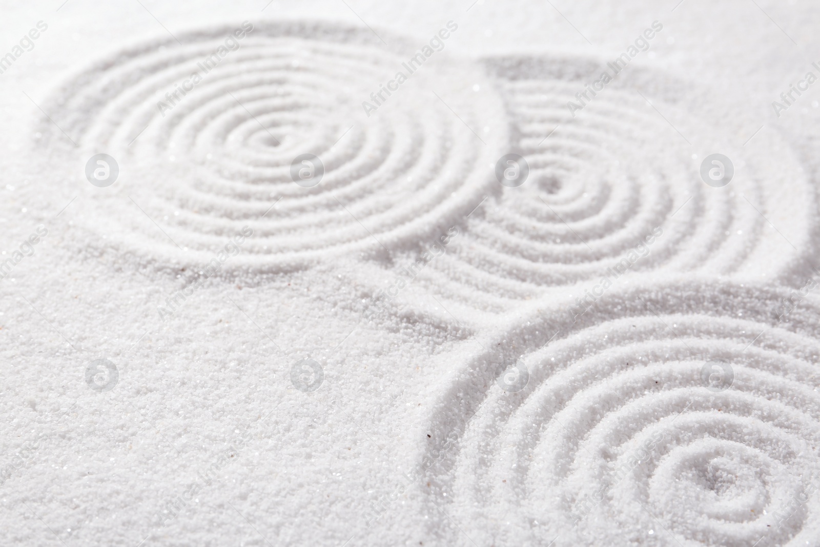 Photo of Zen rock garden. Circle patterns on white sand, closeup