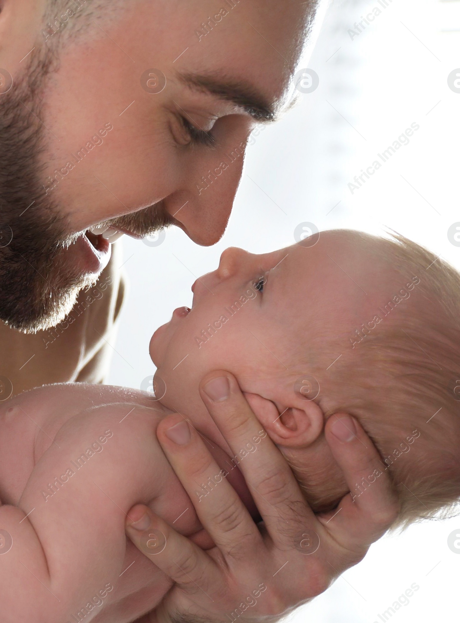 Photo of Father with his newborn son at home