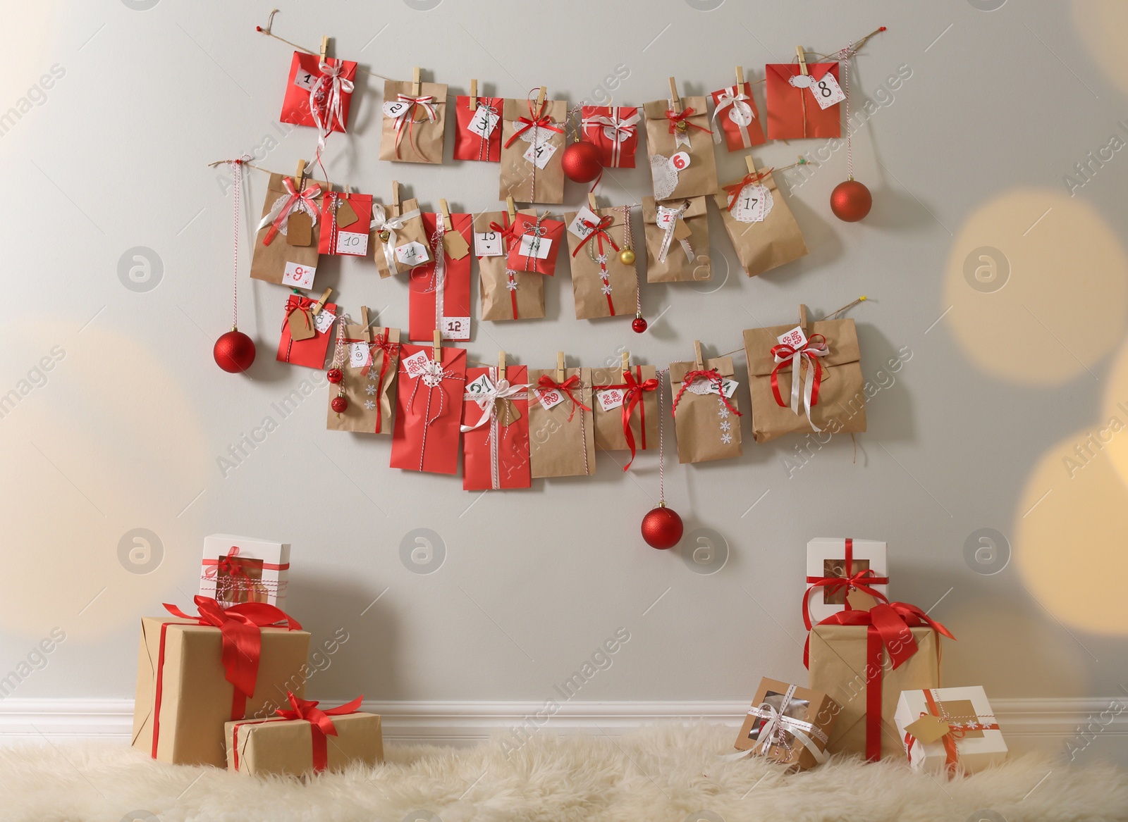 Photo of Christmas advent calendar hanging on wall above gift boxes