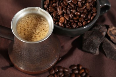 Turkish coffee. Cezve with hot aromatic coffee and beans on table