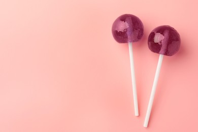 Tasty lollipops on pink background, flat lay. Space for text