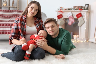 Happy couple with baby celebrating Christmas together at home