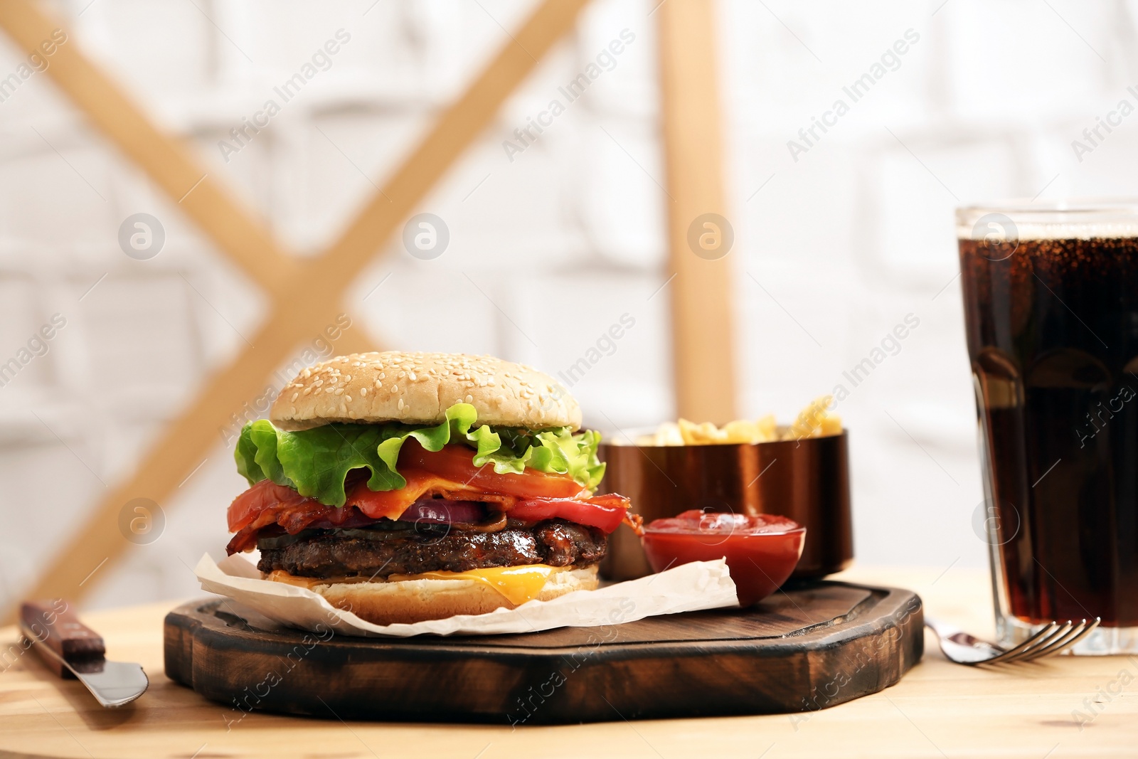 Photo of Burger, soda drink and french fries on table indoors, space for text