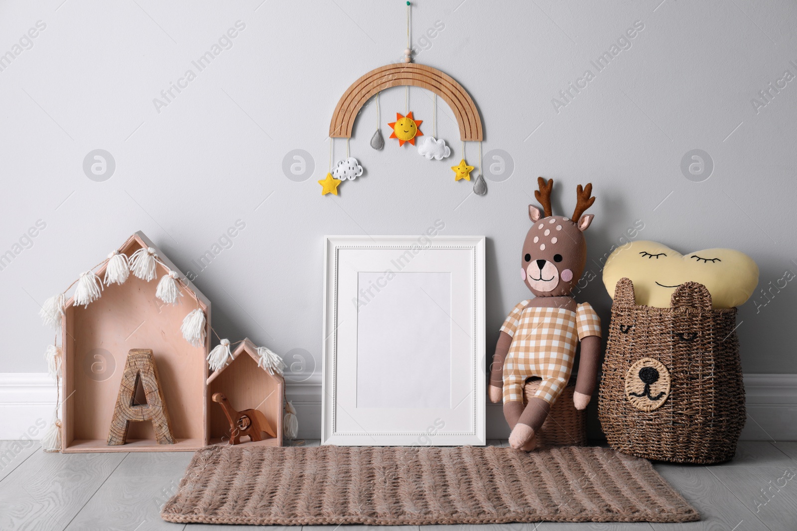 Photo of Empty photo frame and cute toys near wall in baby room. Interior design