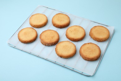 Photo of Tasty sweet sugar cookies on light blue background