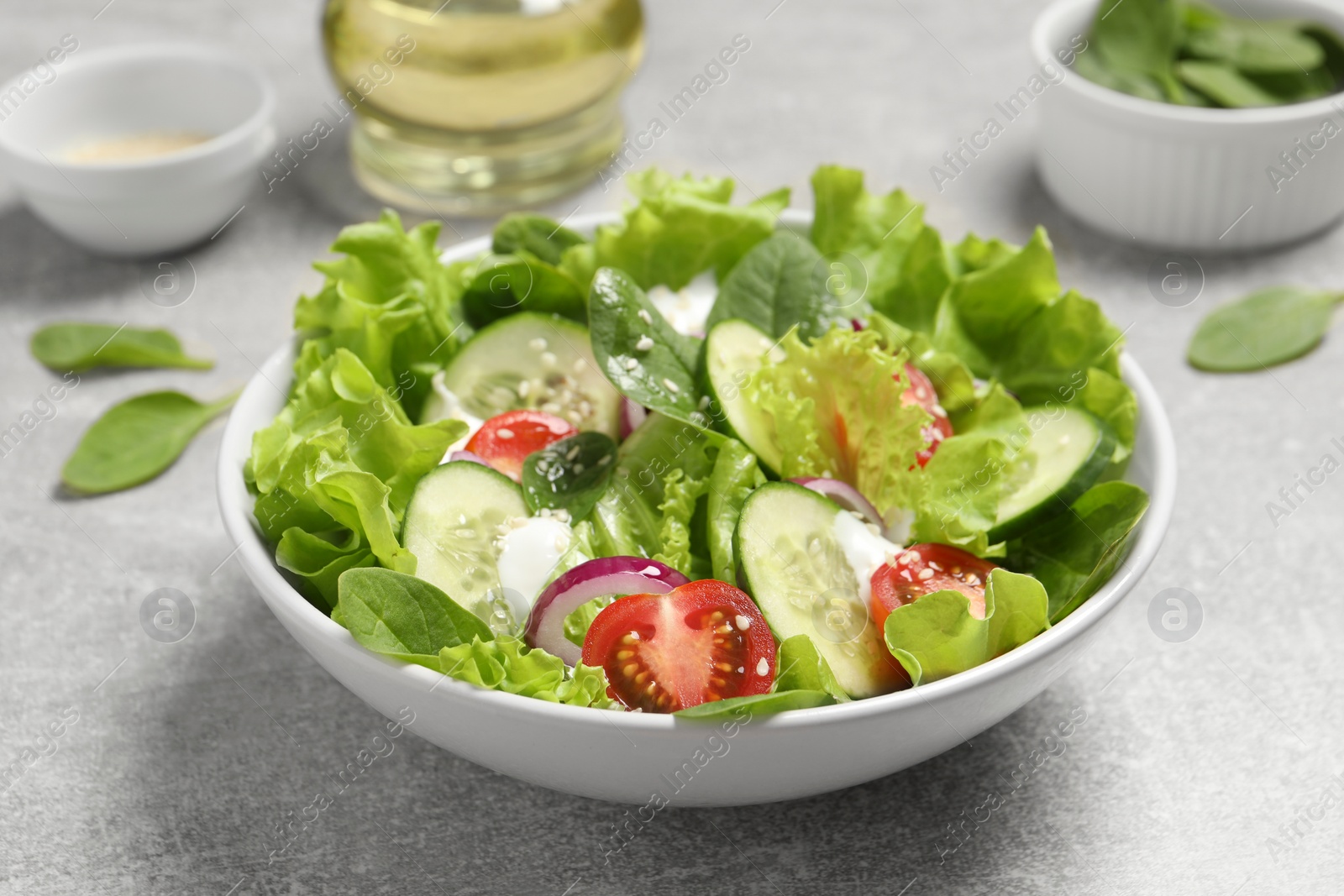 Photo of Delicious salad on light grey table, closeup