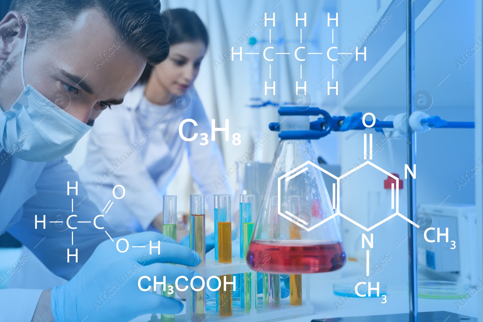 Image of Scientist taking test tube from rack in laboratory