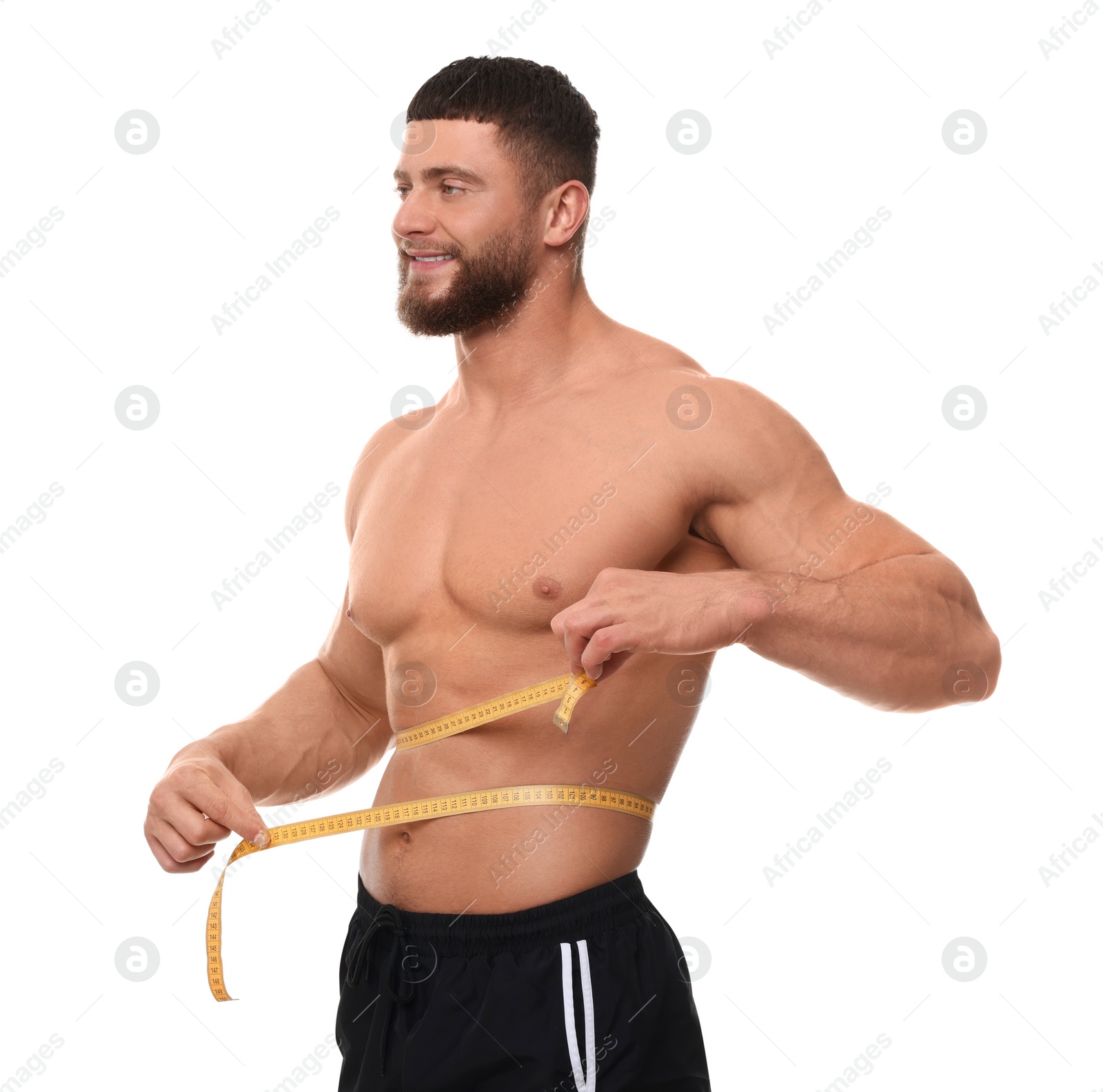 Photo of Happy athletic man measuring waist with tape on white background. Weight loss concept