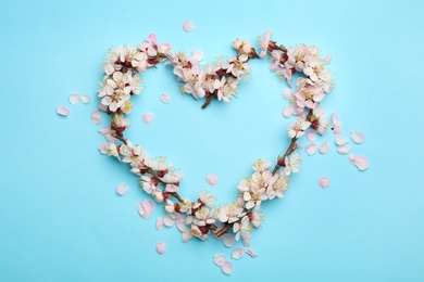 Photo of Heart made of beautiful fresh flowers on color background, top view with space for text. Spring blossom