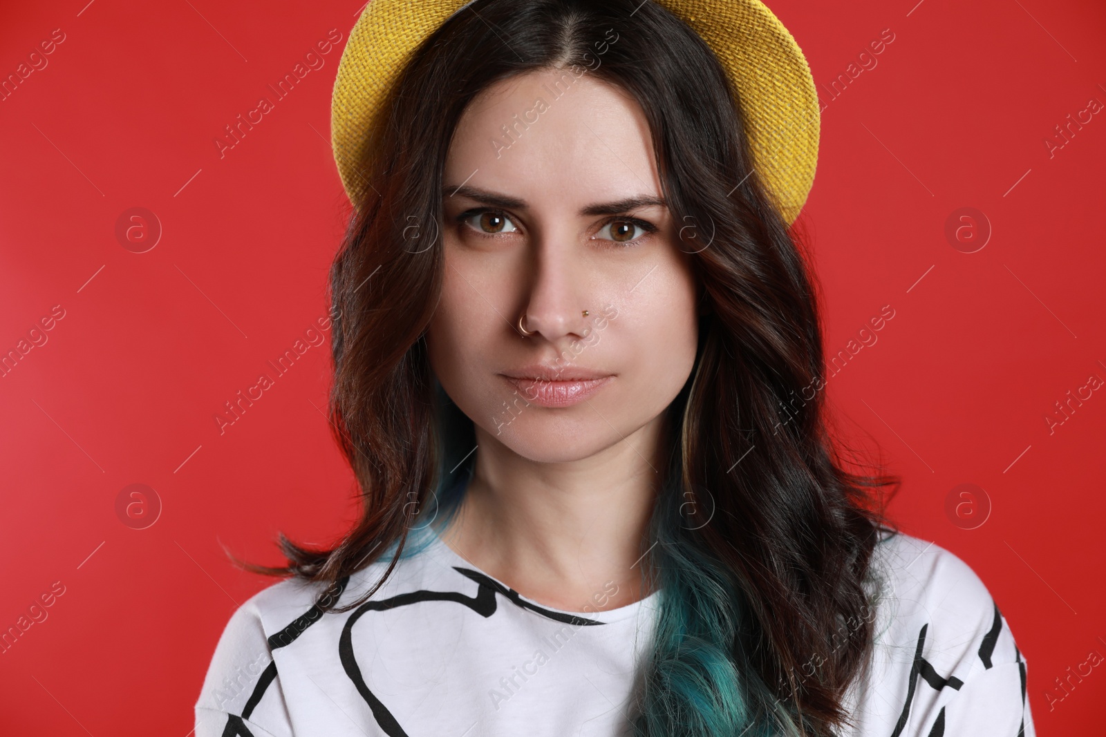 Photo of Beautiful young woman with nose piercing on red background