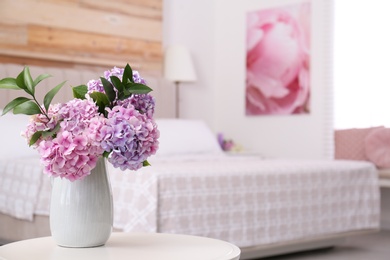 Photo of Bouquet of beautiful hydrangea flowers on table in bedroom, space for text. Interior design