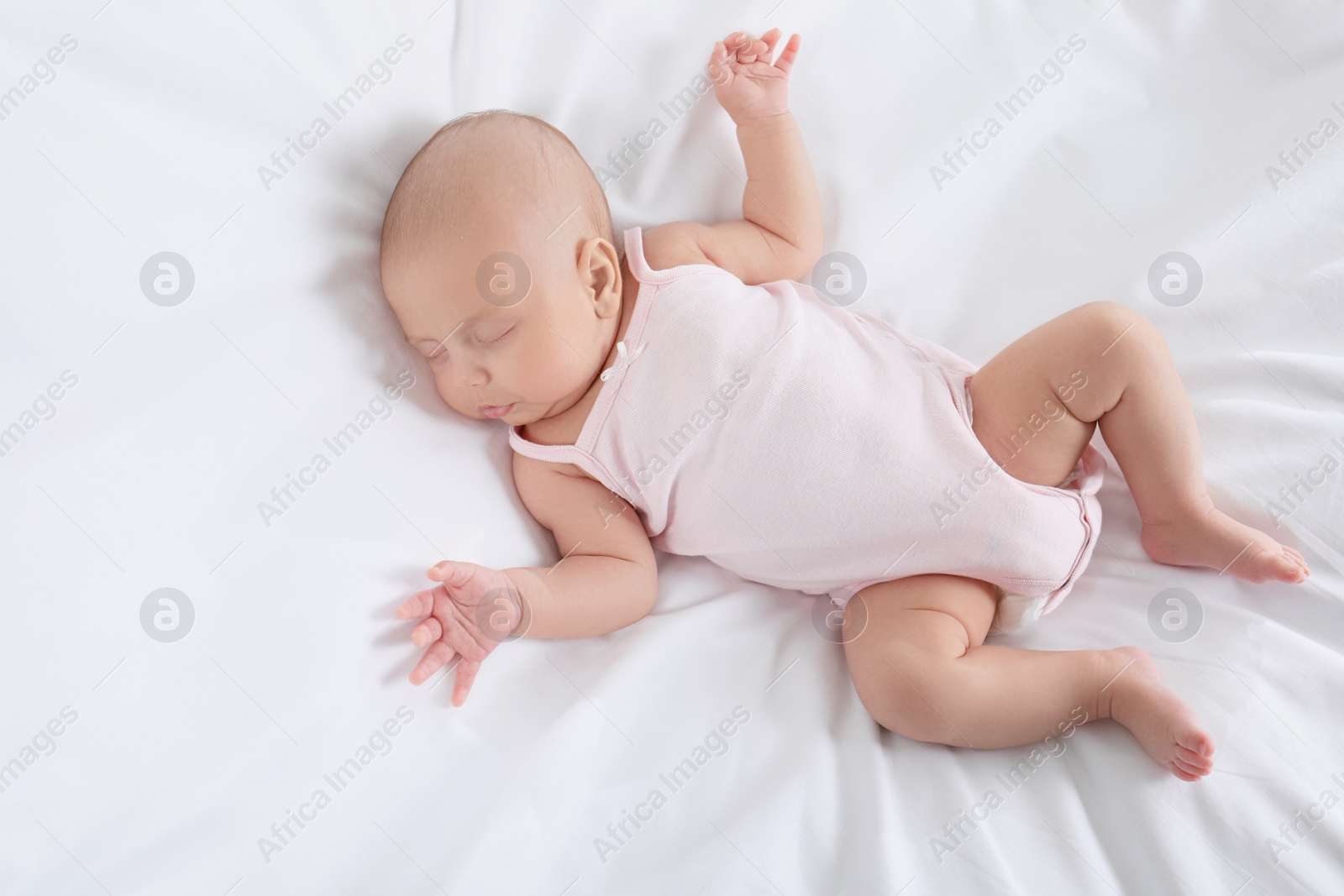 Photo of Cute little baby sleeping on bed, top view