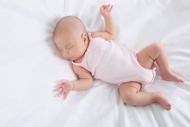 Photo of Cute little baby sleeping on bed, top view