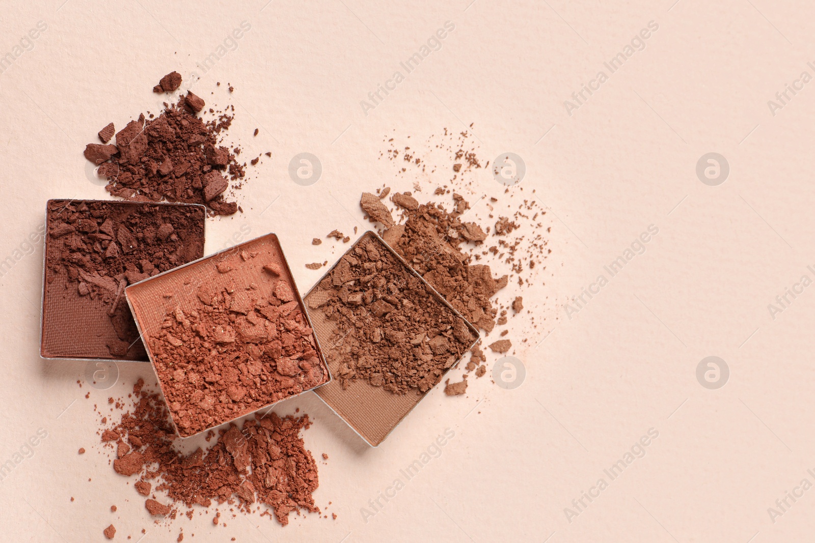 Photo of Different crushed eye shadows on beige background, flat lay. Space for text