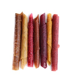 Delicious fruit leather rolls on white background, top view