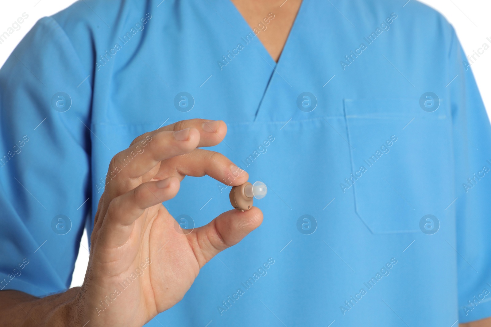 Photo of Male doctor holding hearing aid on white background, closeup. Medical object