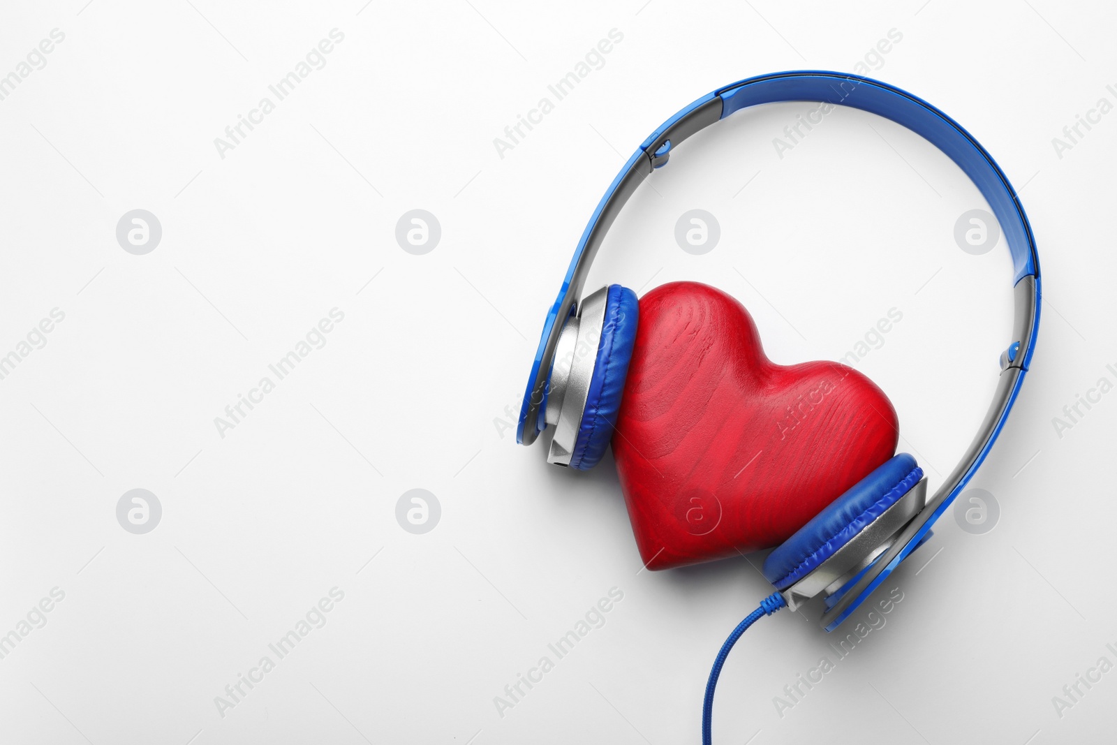 Photo of Decorative heart and modern headphones on white background, top view