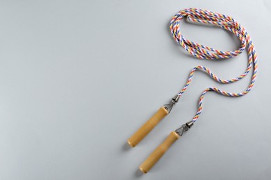 Skipping rope on light grey background, top view. Space for text