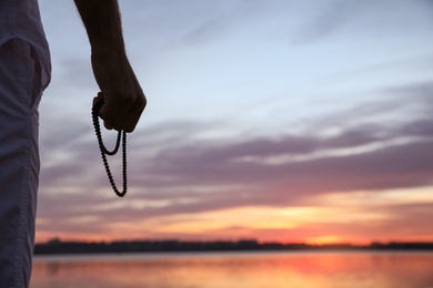 Man near river at sunset, closeup view with space for text. Nature healing power