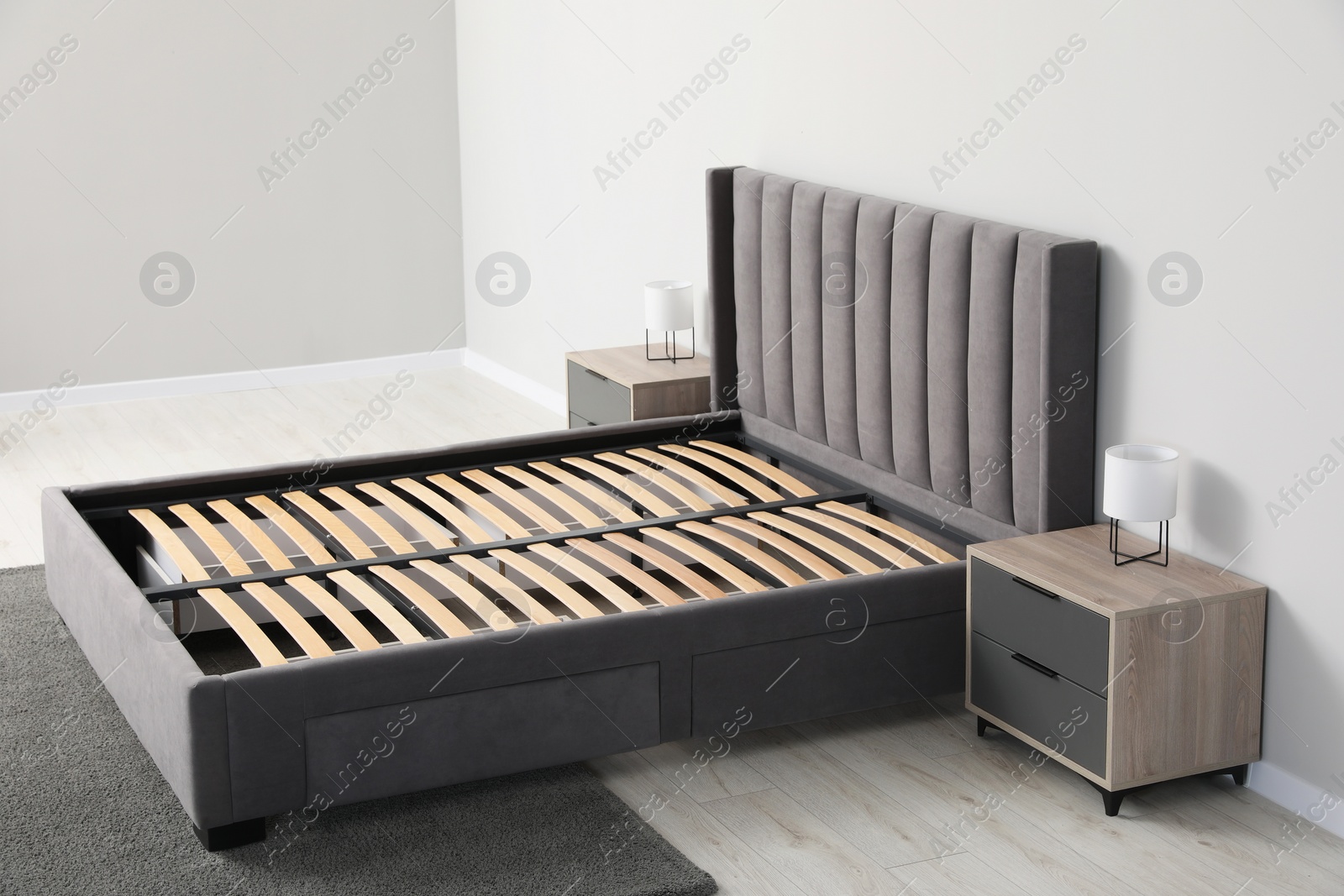 Photo of Comfortable bed with storage space for bedding under slatted base in room