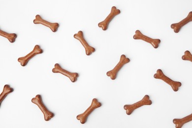 Flat lay composition with bone shaped dog cookies on white background