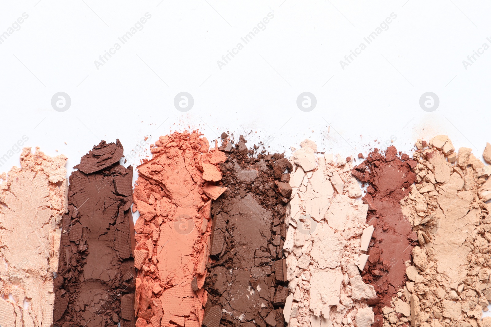 Photo of Crushed eye shadows on white background, top view. Professional makeup product