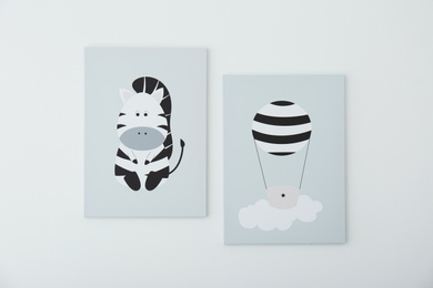 Photo of Adorable pictures of zebra and air balloon on white wall. Children's room interior elements